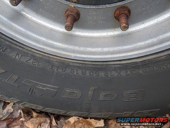 Close-up of a BFGoodrich Baja radial tire on a silver wheel with rusty lug nuts