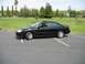 2002 Ford Taurus - A black 2002 Ford Taurus is parked in a lot, with a suburban landscape visible behind it.