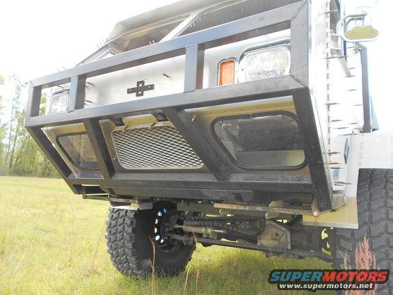 Custom front bumper and grille on a modified vehicle with large tires