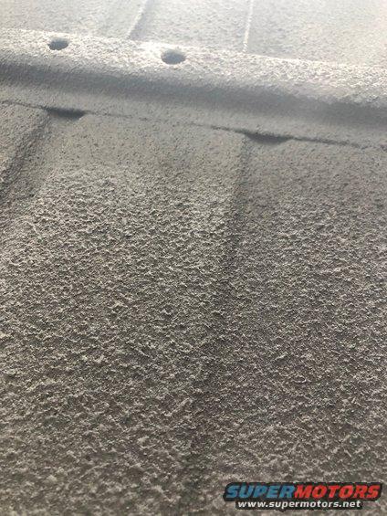 Close-up of textured underbody coating with visible pores and some raised areas