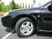 2002 Ford Taurus - Close-up of the front passenger side of a black 2002 Ford Taurus.