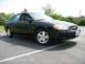 2002 Ford Taurus - A black 2002 Ford Taurus is parked in a lot, showing its front passenger side.