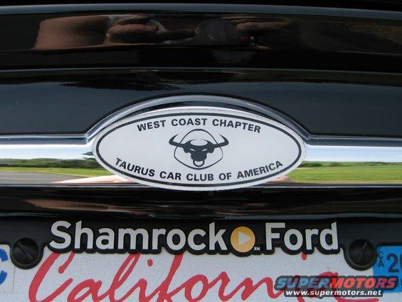 Taurus Car Club of America emblem on black car rear