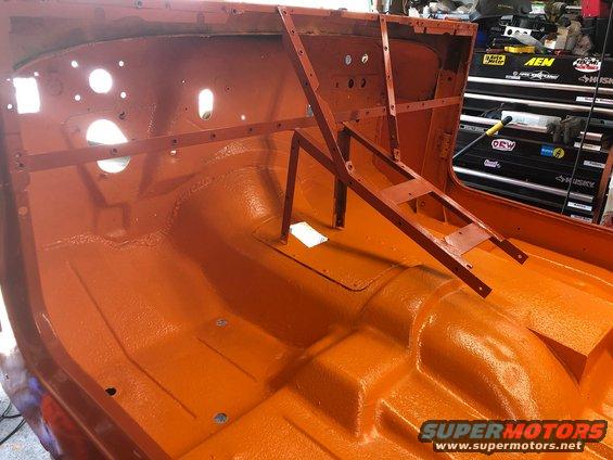 orange-painted interior of a vehicle body, likely a Jeep, with metal bracing installed