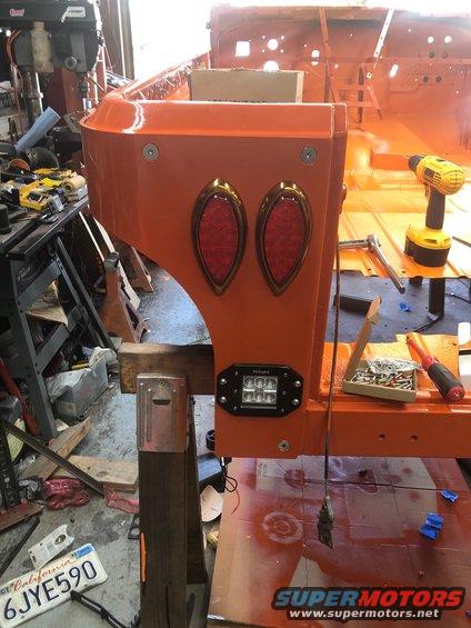 Orange Jeep CJ-7 rear quarter panel with two oval tail lights and a rectangular LED light mounted below