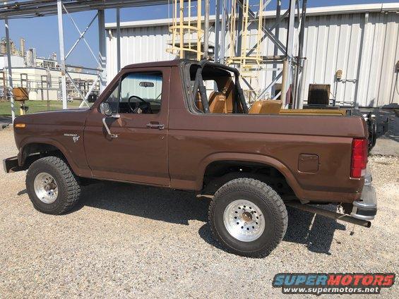 Brown 1980 Ford Bronco with a removable top, seen from the rear passenger side