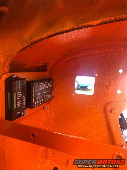 Interior of an orange vehicle showing two electronic modules mounted on the inner panel. One module is labeled GPS-50-2
