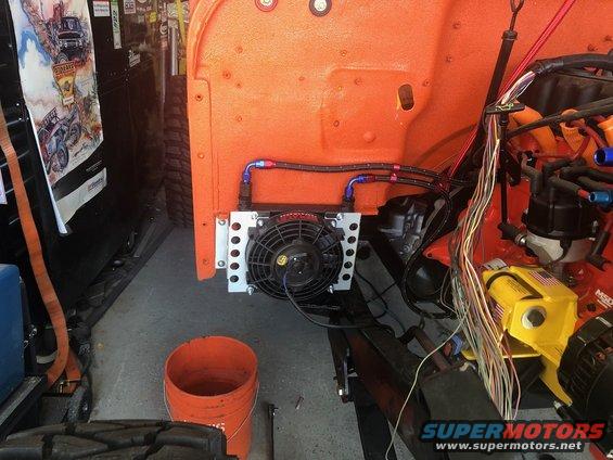 engine bay with orange body panels, oil cooler, fan, and wiring harness