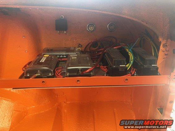 Interior electrical fuse box and wiring in an orange compartment