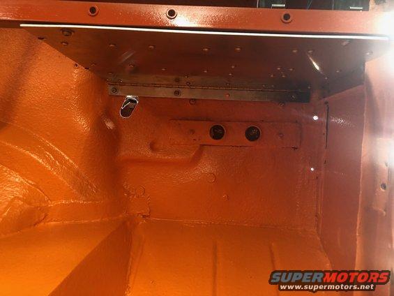 Orange painted interior of a vehicle, possibly a Jeep, showing metal bracing and mounting points