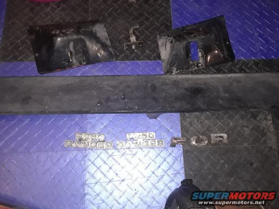 Ford F-250 Ranger emblems and black bumper parts on a blue mat
