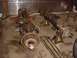 1992 Ford Bronco - Several vehicle axle assemblies and driveshafts are laid out on the floor of a garage.