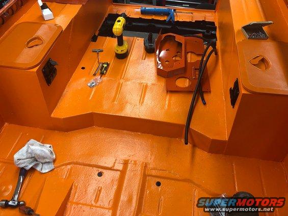 Orange interior floor with tools, including a drill and hammer