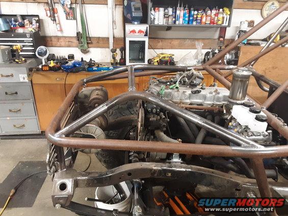 Custom off-road vehicle chassis with exposed engine and roll cage