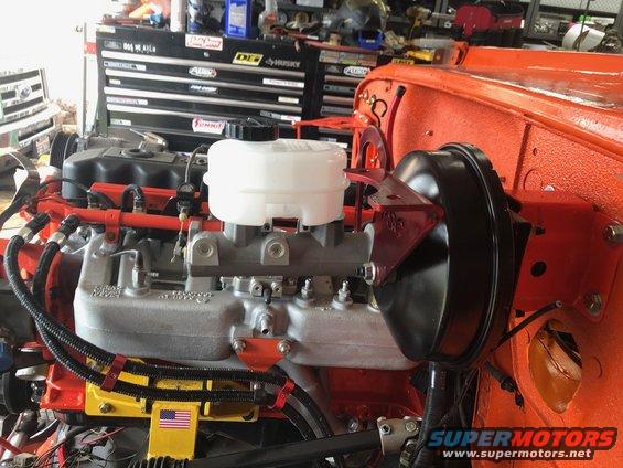 Jeep engine assembly with brake booster and master cylinder. Orange body panels visible