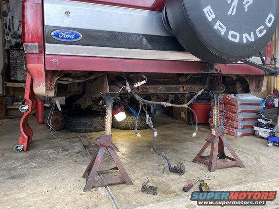 Rear of a Ford Bronco on jack stands with wiring exposed