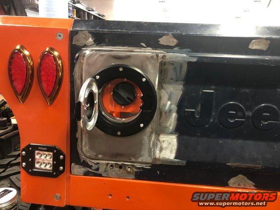 Jeep tailgate with custom fuel door, aftermarket taillights, and a Hilight light