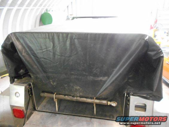 Trailer hitch mechanism with a black tarp covering the top