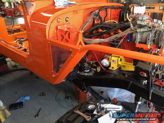 Orange Jeep Wrangler chassis with exposed engine and wiring, viewed from the front 3/4 angle
