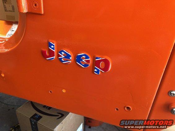 Orange Jeep body panel with red, white, and blue Confederate flag emblems spelling 'Jeep'