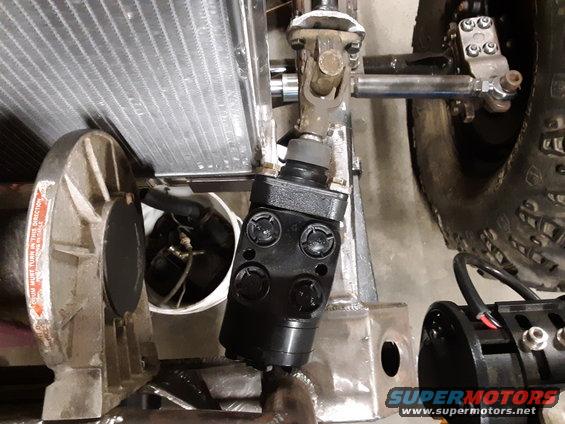 Black steering component near a radiator and a tire