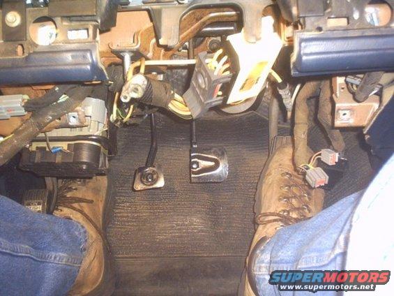 Driver's side footwell with pedals and wiring harness visible