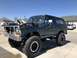 1979 Ford Bronco - This lifted Ford Bronco sits on large off-road tires with its hood open, revealing the engine bay.