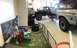 1979 Ford Bronco - Two Ford Broncos are undergoing work in a garage, with children playing nearby in a protected zone.