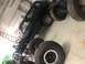 1979 Ford Bronco - A dark green SUV is elevated on stands, surrounded by large off-road tires in a garage setting.