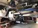 1979 Ford Bronco - Custom suspension components are secured with blue straps on a vehicle frame, suggesting a modification or repair process.