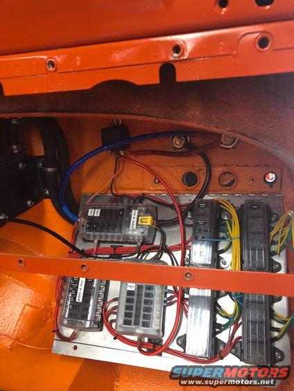 Vehicle fuse box with multiple clear-covered fuse holders and wiring. Some labels are visible