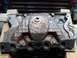 1978 Ford Bronco - A cast iron engine intake manifold is shown, resting on wooden blocks in what appears to be a workshop.