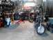 1978 Ford Bronco - A motorcycle sits in a garage filled with tools, car parts, and a shop vac.