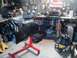 1978 Ford Bronco - An engine sits on a stand in a workshop filled with tools and supplies.