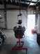 1978 Ford Bronco - Engine assembly being worked on in a garage, suspended by a hoist and on an engine stand.