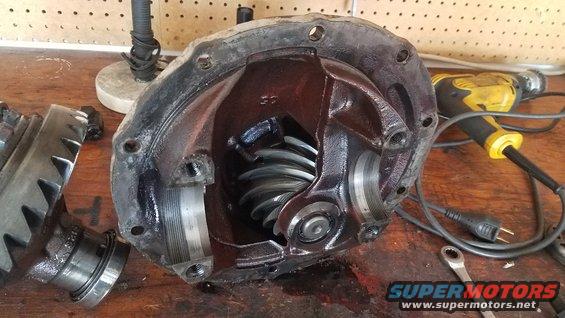 Differential housing with gears and pinion visible. Tools and workbench in background