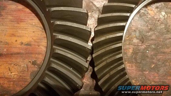 Differential gears on a wooden surface, showing wear and damage