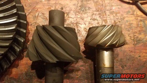 Two differential gears, one large and one small, on a wooden surface