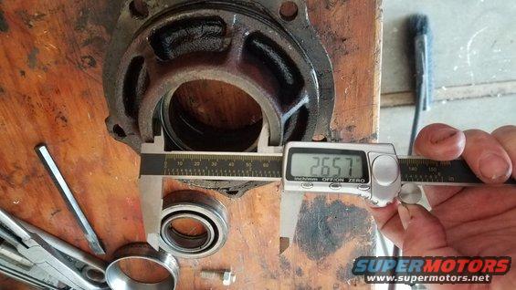 Differential housing being measured with digital calipers showing 26.57