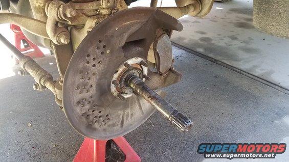 Front wheel hub assembly with brake rotor and caliper removed, showing spindle and suspension components