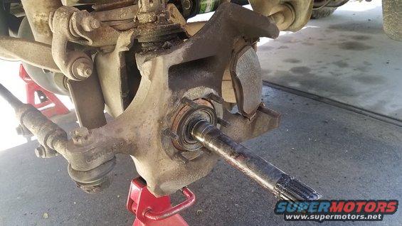 Vehicle suspension assembly with exposed spindle and brake caliper
