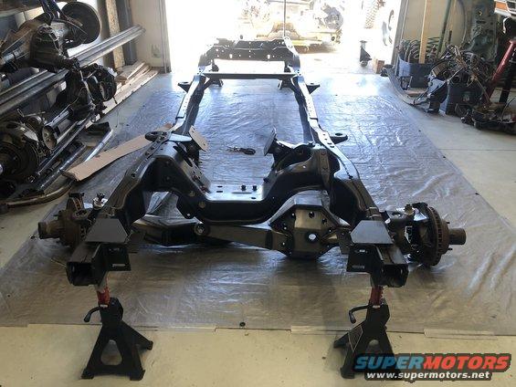 Vehicle frame on jack stands, front suspension visible