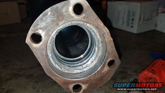 Close-up of a rusty exhaust flange with a pipe opening