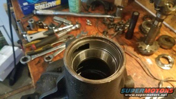 Differential housing with bearing races and assorted tools on a wooden workbench