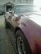 1993 Ford Bronco - Maroon sports car with a distinctive fender shape and alloy wheels.