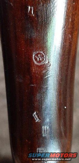 close-up of wood with some stamped markings and a circular emblem