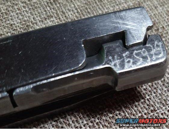 Close-up of a metal part with '4F2S9B' etched into it