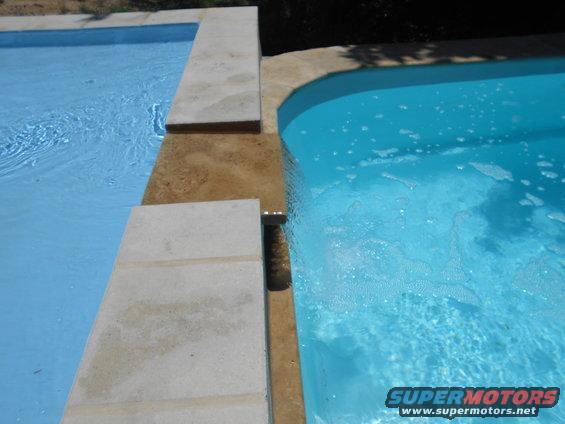 Two swimming pools with concrete and stone coping