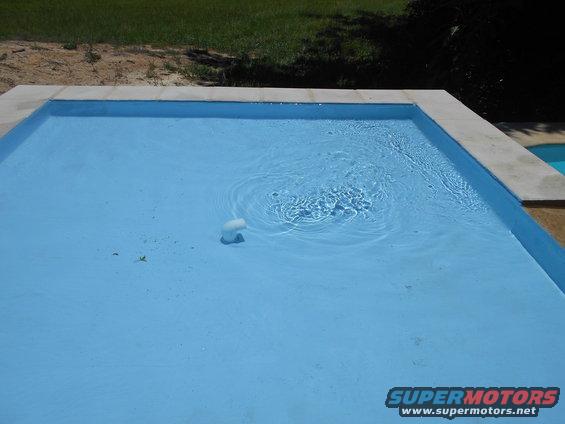 Swimming pool with water jets and a white pool cleaner