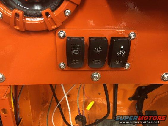 Custom orange dashboard panel with three toggle switches labeled HEAD LIGHTS, DRIVING LIGHTS, and REAR LIGHTS. Wiring is visible below